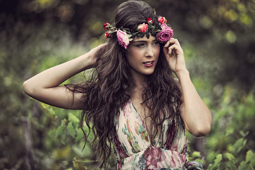 romantic beautiful woman summer portrait with wreath of flowers in field