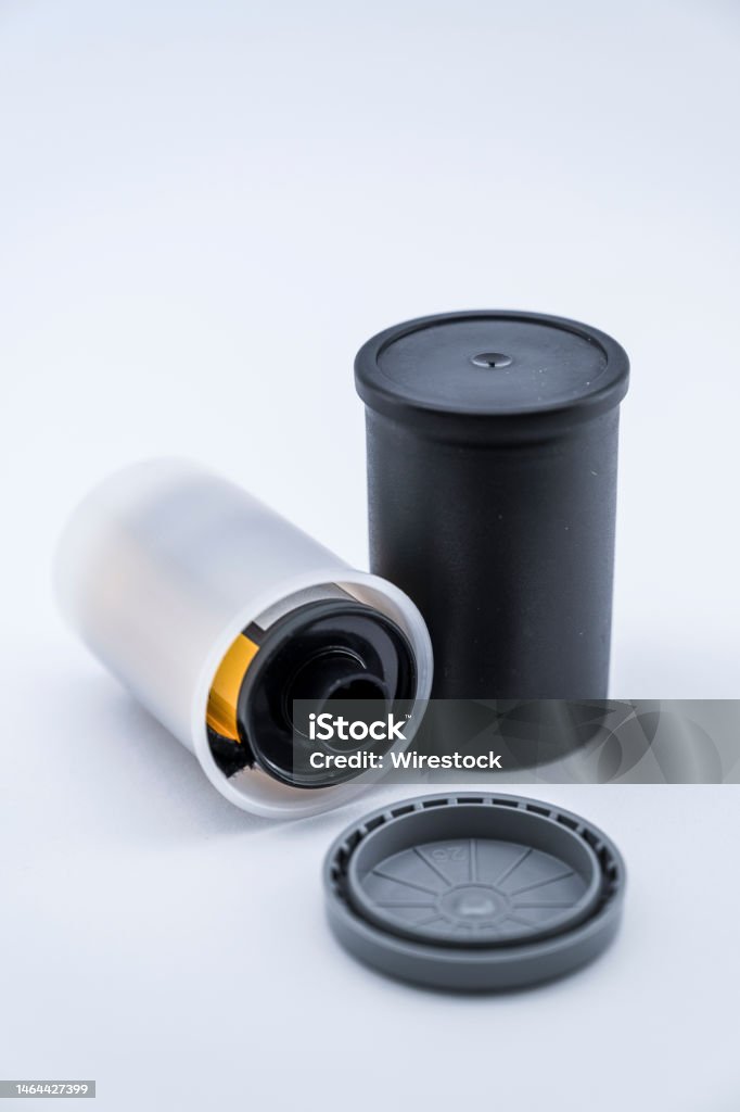 A vertical shot of Film canisters. A vertical shot of a black and white Film canister with white background. Analog Stock Photo