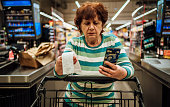 Senior woman checking bill after shopping at the supermarket
