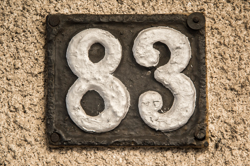 Old retro weathered cast iron plate with number 83