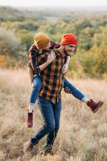 istock Cheerful guy and girl on a walk in bright knitted hats 1464433521