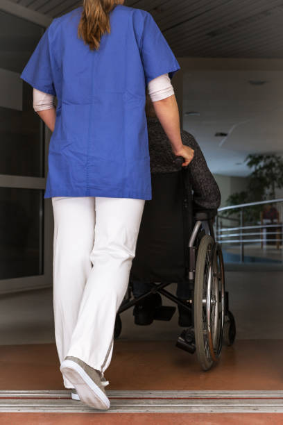 istock nurse rolls a patient in a wheelchair 1464434288