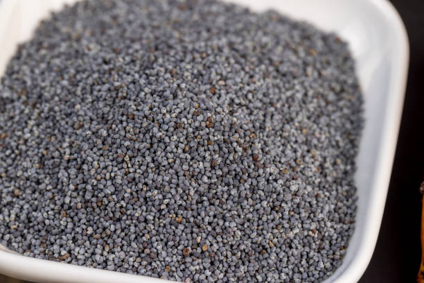 A large number of poppy seeds on the cooking table A large number of poppy seeds on the cooking table, using ripe poppy seeds on the kitchen table during cooking poppy seed stock pictures, royalty-free photos & images