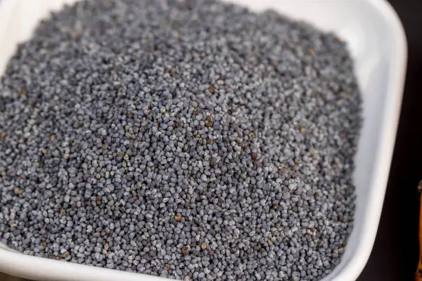 A large number of poppy seeds on the cooking table, using ripe poppy seeds on the kitchen table during cooking