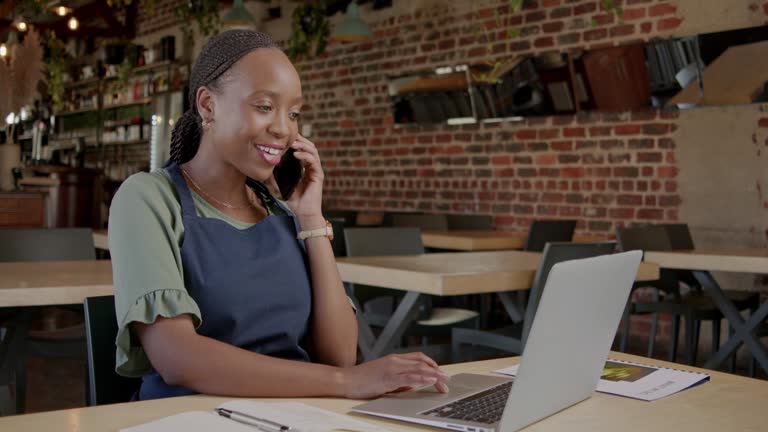 Cafe, phone call planning or black woman on laptop for web store assistance, stock order or B2B sale. Small business, happy or manager with smartphone for communication, networking or online shopping
