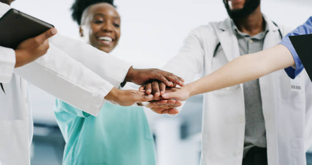 People stack hands in hospital, teamwork in medical group with doctors and nurses smile together. Proud healthcare professionals celebrate success, employees in the workforce and staff solidarity las personas se apilan en el hospital, el trabajo en equipo en grupo médico con médicos y enfermeras sonríen juntos. los profesionales de la salud celebran el éxito y los objetivos, los empleados en la fuerza laboral y la solidaridad del personal