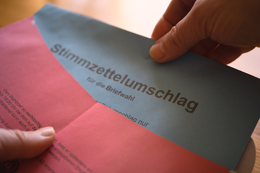 Close-up of hands close the postal voting envelope
