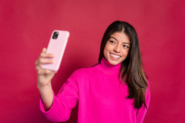 istock Smiling woman taking selfie on smartphone 1464439985