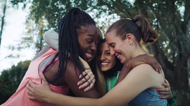 Group of Female Teenagers Stacking Their Hands Together as a Team and Ending with a Cheer and a Hug. Multiethnic Girls Gathered in a Huddle Preparing a Strategy for a Friendly Basketball Match