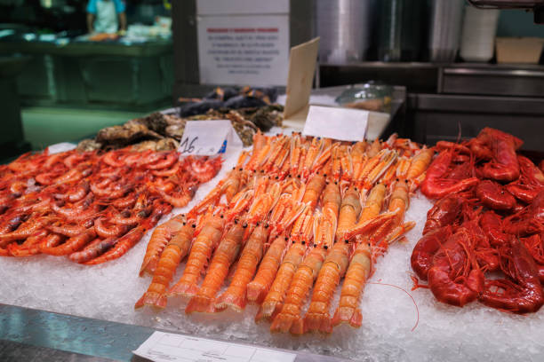 Fresh Shellfish, freshly caught Shrimp and Langoustines displayed on ice above a Market Stall.