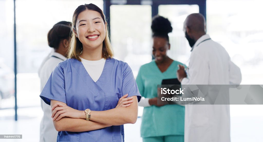 Healthcare, portrait and nurse with crossed arms in the hospital standing in the lobby after consultation. Happy, smile and professional Asian female medical worker with leadership in medicare clinic Healthcare And Medicine Stock Photo