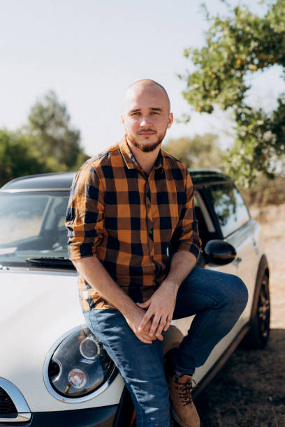 istock Guy in a plaid shirt next to a white car 1464442008
