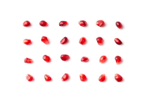 istock Pomegranate seeds are neatly arranged on a white background top view. 1464442096