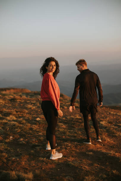 istock Smiling couple walking over green hills 1464443011