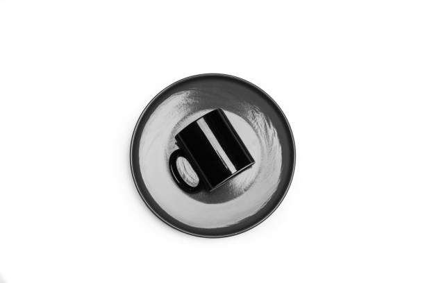 istock A black mug on a gray plate on a white background with copy space 1464447172