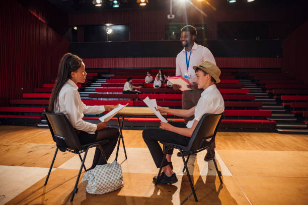 Rehaearsing In Class A close up wide angle view of two teenage students rehearsing in a school theatre in the North East of England. They are learning and going over their scripts for the performance. actor class stock pictures, royalty-free photos & images