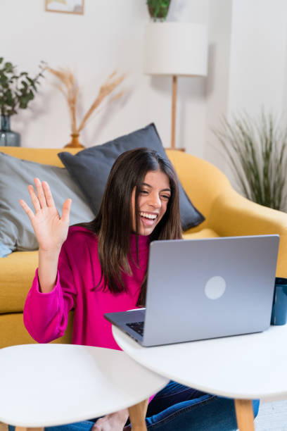 istock Happy woman using laptop on sofa having a video call 1464458944