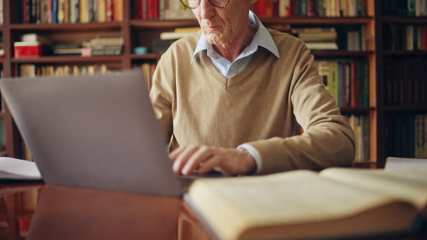 istock Senior man working on laptop, writing an article, doing research, freelance job 1464459325