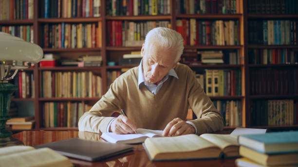 istock Male scientist doing research in the library, reading books and writing down notes 1464459778