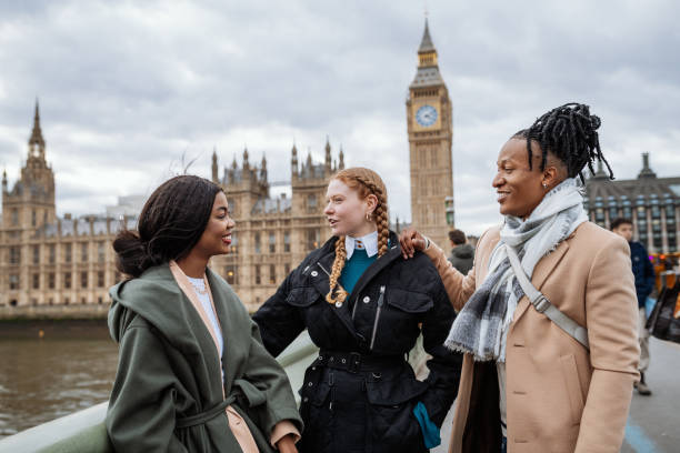 britische jugend im winter, draußen, in der nähe von big ben stehen und reden - street london england city of westminster uk stock-fotos und bilder