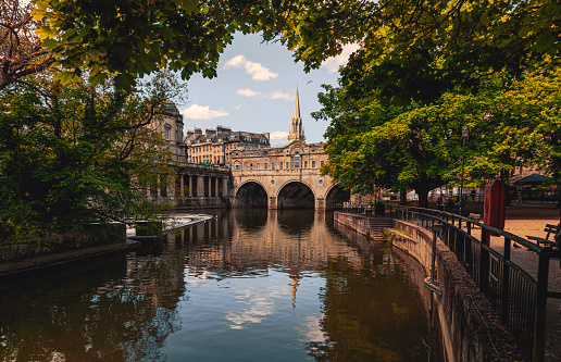 Landscape view of Bath Pulteney Bridge \nover River Avon in Bath, Somerset, England United Kingdom in spring time. Bath and North East Somerset unitary area in the county of Somerset England, known for and named after its Roman-built baths.