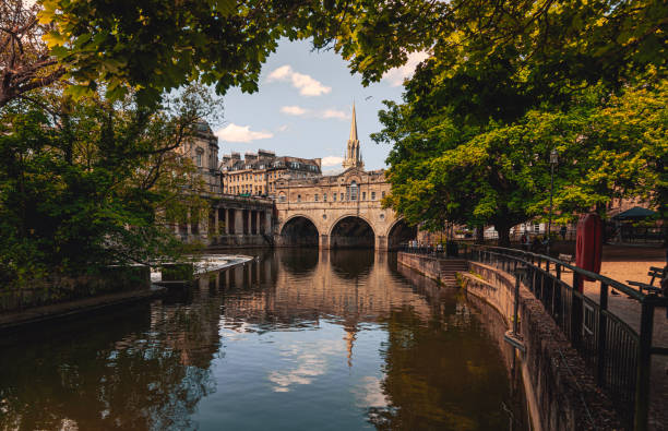 мост палтни и река эйвон в бате, сомерсет, англия - roman baths стоковые фото и изображения