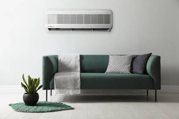 istock Modern air conditioner on light wall in room with stylish sofa 1464462282
