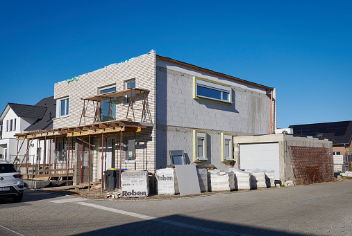 Grevenbroich, Germany - Feb. 08, 2023:  Construction site of a unfinished contemporary one-family house in a new housing area of Grevenbroich, North-Rhine-Westphalia.