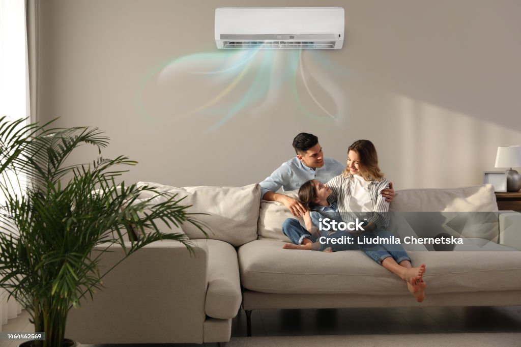 Happy family resting under air conditioner on beige wall at home - Royalty-free Ar-condicionado Foto de stock Happy family resting under air conditioner on beige wall at home - Royalty-free Ar-condicionado Foto de stock