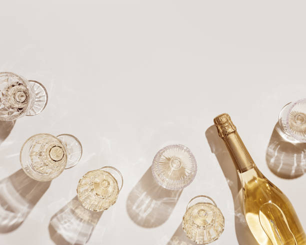 Top view white sparkling wine in different glasses of wine, stemmed glass with sun shadow and glare on light beige background. White wine tasting concept flat lay, copy space. Summer drinks Top view white sparkling wine in different glasses of wine, stemmed glass with sun shadow and glare on light beige background. White wine tasting concept flat lay, copy space. Summer alcoholic drinks champagne stock pictures, royalty-free photos & images