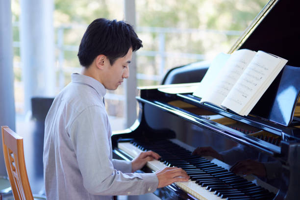 istock Young Japanese man playing the piano 1464464844