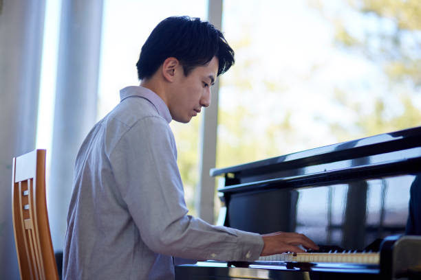 istock Young Japanese man playing the piano 1464464845