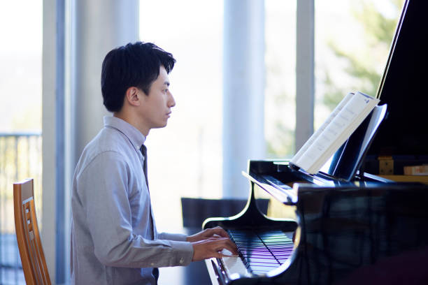 istock Young Japanese man playing the piano 1464464849