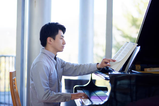 istock Young Japanese man playing the piano 1464464860