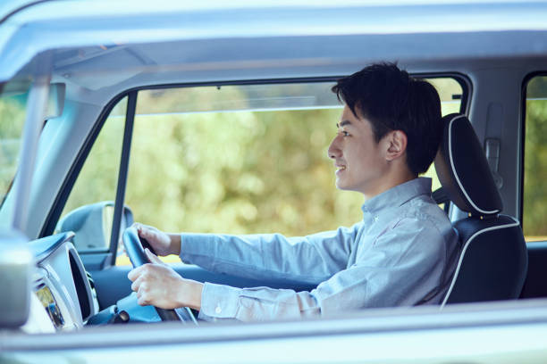 young japanese man driving a car - fordon på land bildbanksfoton och bilder