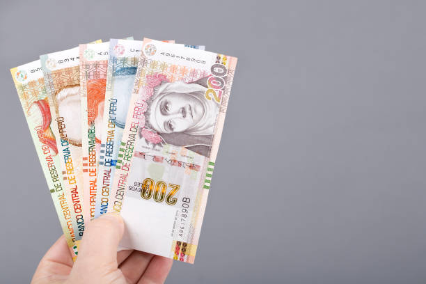 istock Peruvian money in the hand on a gray background 1464468060