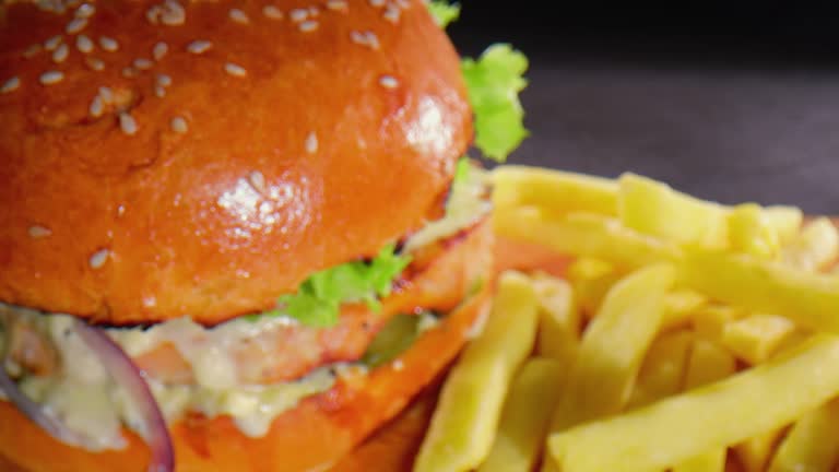 Tasty lucious burger on a wooden board with fries and ketchup - close up