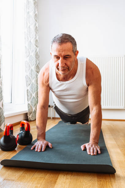 istock Athletic active gray-haired middle-aged man shaking arms and back 1464470726
