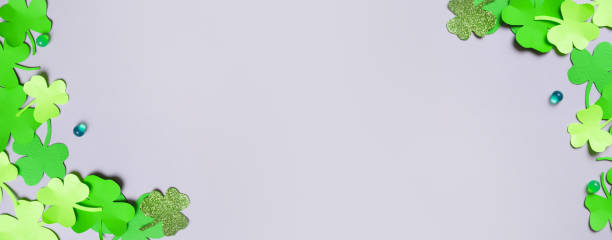 istock St. Patrick's Day minimalistic banner background. Paper clover leaves on grey background with copy space 1464472818