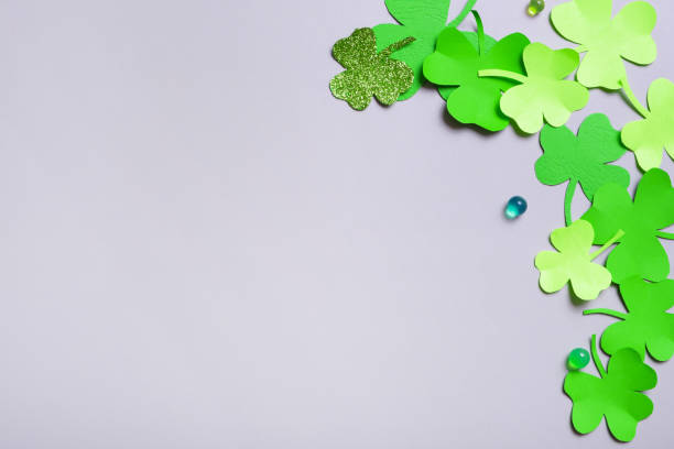 istock St. Patrick's Day minimalistic background. Paper clover leaves on grey background with copy space 1464472969
