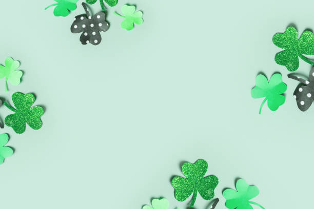 istock St. Patrick's Day balnk greeting card. Paper clover leaves on colored background with copy space 1464472998