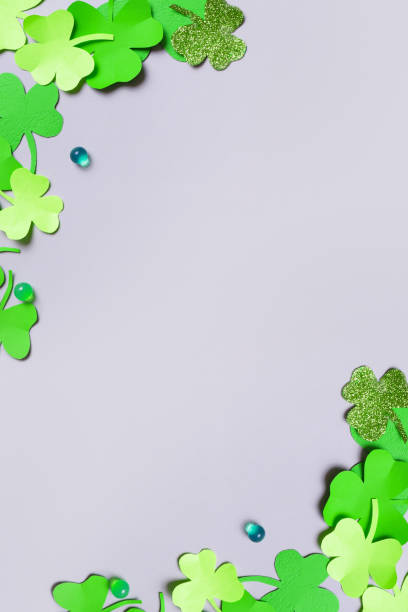 istock St. Patrick's Day minimalistic vertical background. Paper clover leaves on grey background with copy space 1464473000