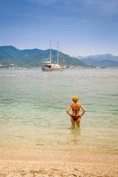 istock Woman in bikini watching the floating yacht 1464474917