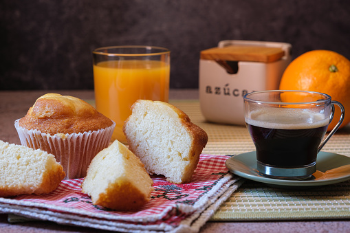 Breakfast of muffins with coffee and orange juice on green place mat