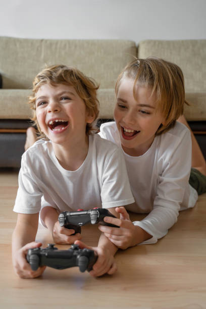 istock Cute children joyful playing video games with controller console, brother sister expressing emotions while enjoying their hobby playstation joystick. Vertical 1464479371