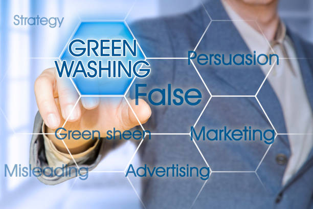 Alert to Greenwashing - concept with business manager pointing to icons against a digital display stock photo
