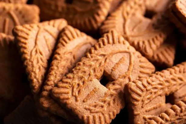 Photo of A portrait of a stackof brown cookies called speculoos or speculaas in Belgium or the Netherlangs. The spiced biscuit is very delicious and popular during the winter period to be eaten at any time.