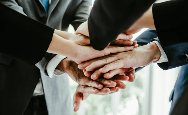 istock close up business people putting their hands together.Unity and teamwork concept 1464482743