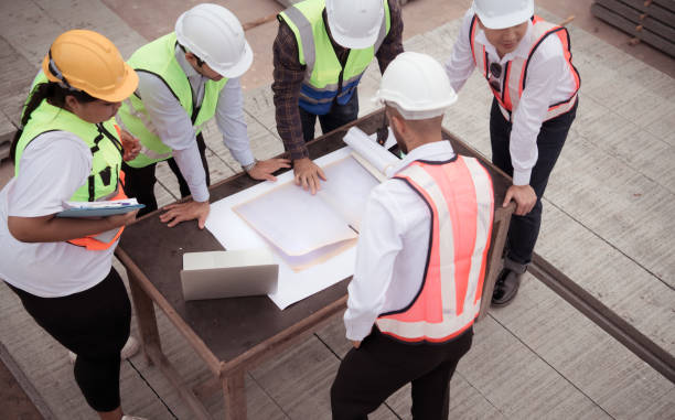 istock Construction engineers, architects, and foremen form a group. Participate in a meeting to plan new construction projects. 1464484824