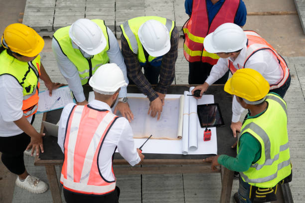 istock Construction engineers, architects, and foremen form a group. Participate in a meeting to plan new construction projects. 1464484899